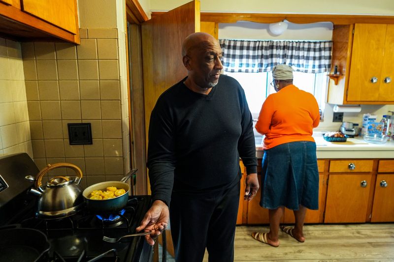 Melvin Bishop, 69, of Detroit, prepares dinner in the kitchen with his wife, Jan Bishop, 64, on Monday, May 11, 2026.