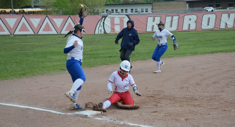 New Boston Huron's Rihanna Sartin slides safely into third base as Jefferson's Emily Grube snags a high throw on Wednesday, May 13, 2026. Backing up the play is shortstop Alivia LeBrun.