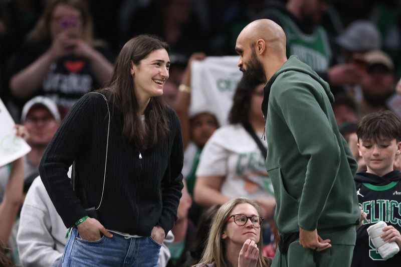 Boston Fleet defenseman Megan Keller (Farmington Hills) speaks with Boston Celtics guard Derrick White (9) during the second half against the Orlando Magic at TD Garden in April.