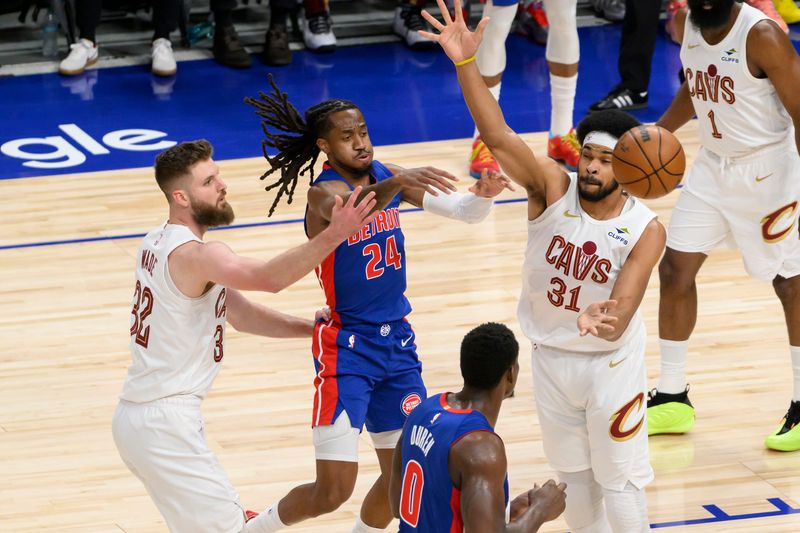 Detroit guard Daniss Jenkins passes the ball away from Cleveland forward Dean Wade, left, and center Jarrett Allen during the first quarter.