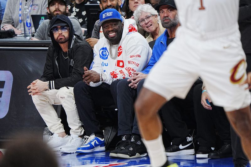 Rappers Eminem and 50 Cent sit courtside during the first half of Game 5 in the second round of the NBA playoffs at Little Caesars Arena in Detroit, Wednesday, May 13, 2026.