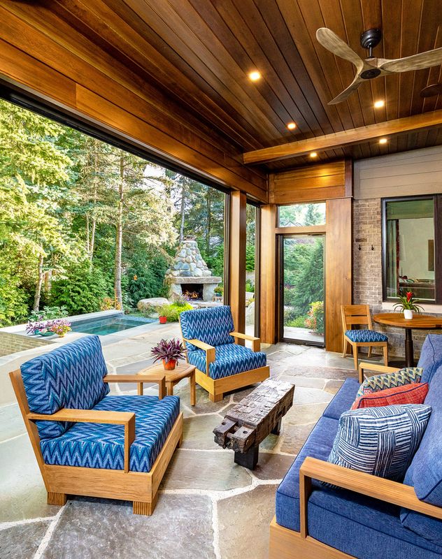 Teak seating with colorful cushions makes this patio a destination. Retractable screens keep the bugs at bay.