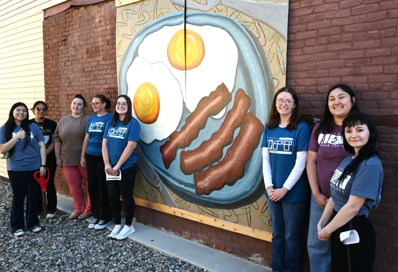 Eight of the 20 students from Coldwater High School art programs who created this mural representing Jeannie's Diner downtown Coldwater.