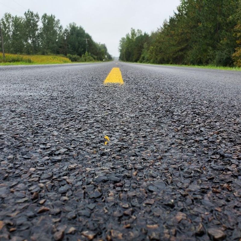 Saganing Road in Bay County's Gibson Township is pictured after rubber-modified chip seal, using rubber from scrap tires, was applied over an existing asphalt road by the Bay County Road Commission in June 2021.