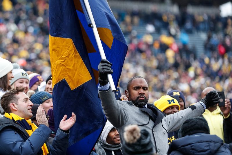 Charles Woodson waves a Michigan flag among fans before the Ohio State game at the Michigan Stadium in Ann Arbor, Saturday, Nov. 30, 2019.