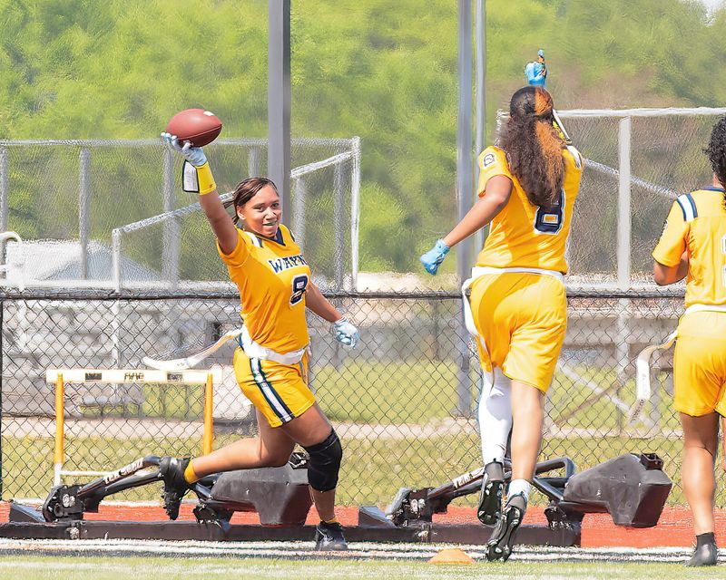 Wayne Memorial's Skyann Penn celebrates her game winning pick-six during a Michigan Girls High School Flag Football League game on Sunday, May 17, 2026.