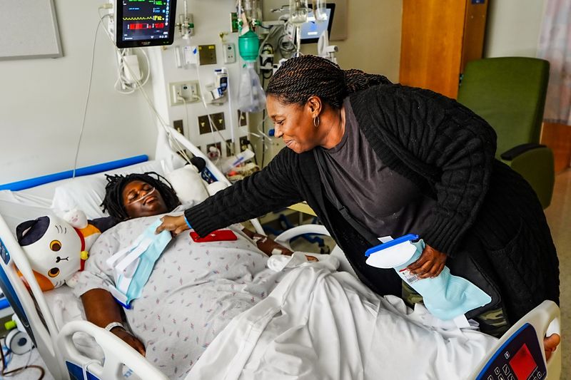 Tracey Clark, 46, of Detroit, places ice packs on her son Tavuan Clark’s chest, while he recovers from a gunshot wound that barely missed his heart, at Children’s Hospital of Michigan in Detroit, Tuesday, May 19, 2026. Clark is expected to fully recover after being shot in the chest about 9:40 p.m. Sunday, May 17, in the area of Library Street and Grand River Avenue, Detroit Police Chief Todd Bettison said at the scene that evening. Two older teens were taken into custody.