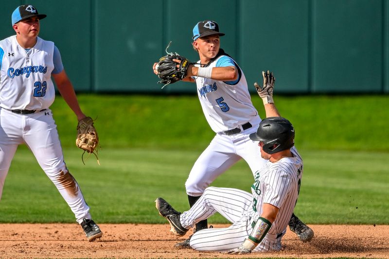 Lansing Catholic's Ethan Link, center, turns a double play against Williamston as the Hornets' Miles Keener, below slides in the third inning on Tuesday, May 19, 2026, during the Diamond Classic at McLane Stadium in East Lansing.