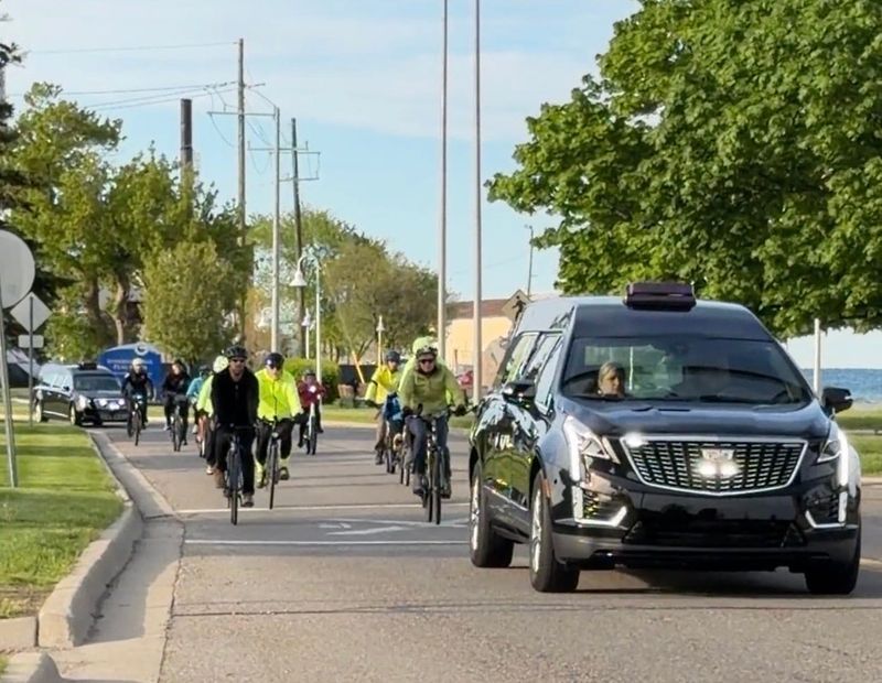 A hearse and cyclists travel south along the Thomas Edison Parkway during the Ride of Silence on May 20, 2026 in Port Huron. The annual memorial ride raises awareness about bicycle safety and honors injured and fallen cyclists.