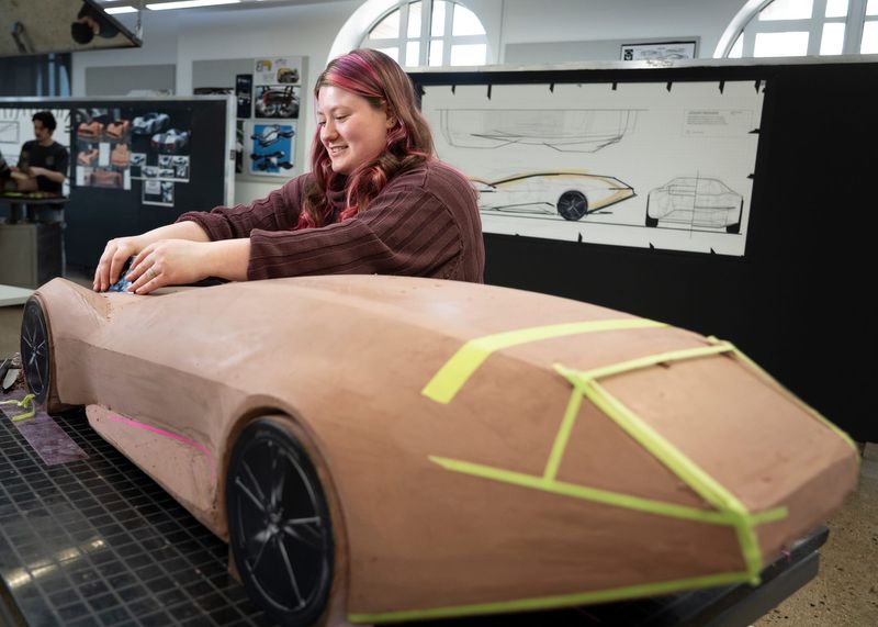 Madison Blood, a senior in transportation design at the College for Creative Studies, works on her clay model of a Jaguar concept car on Thursday, March 19, 2026, in Detroit.