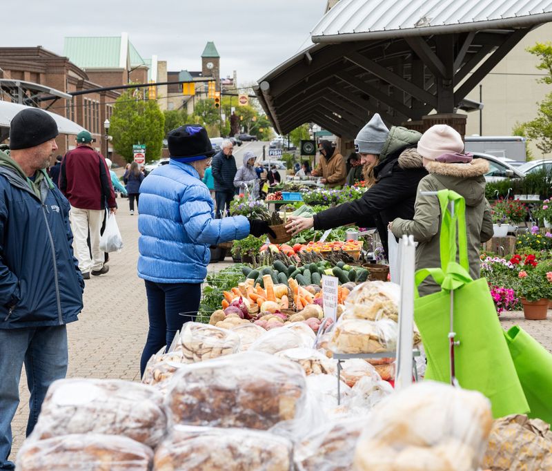 Market-goers purchase fresh produce at the Holland Farmers Market on Wednesday, May 13.