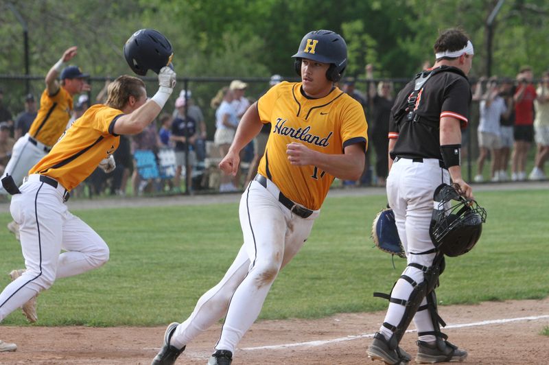 Hartland players rush the field as Logan Randall crosses the plate with the winning run in a 5-4 victory over Brighton during a pre-district baseball game on Tuesday, May 26, 2026.