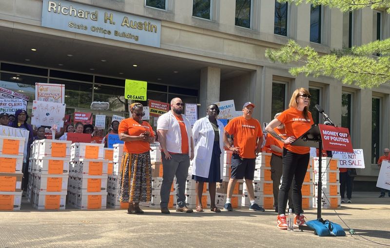Christy McGillivray, co-chairwoman of the steering committee for Michiganders for Money Out of Politics, speaks on Wednesday, May 27, 2026, as the campaign submits more than 562,000 at the Secretary of State's Lansing headquarters.