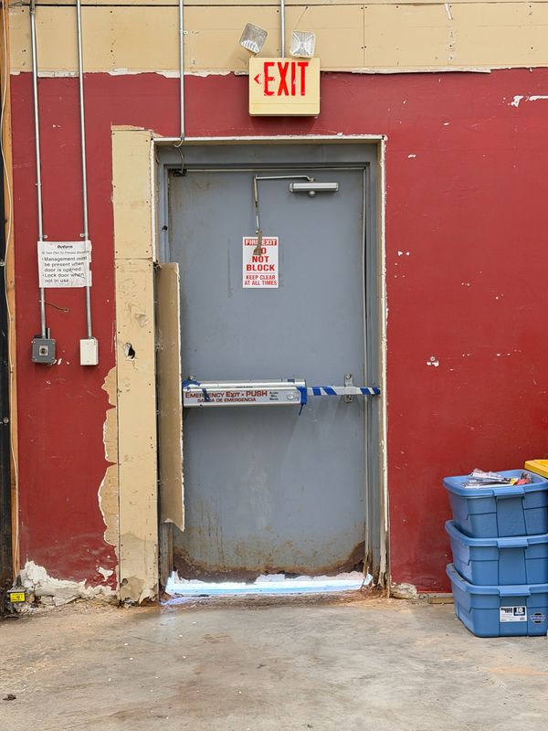 Rust and water damage are visible around an emergency exit door inside a leased tenant space at Birchwood Mall on May 19, 2026 in Fort Gratiot Township.