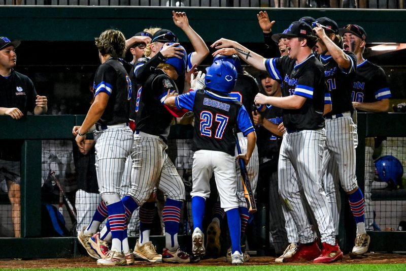 Mason swarms Travis Davis and Joey Schild after they scored against Grand Ledge in the sixth inning on Wednesday, May 27, 2026, during the Diamond Classic semifinal at McLane Stadium in East Lansing.