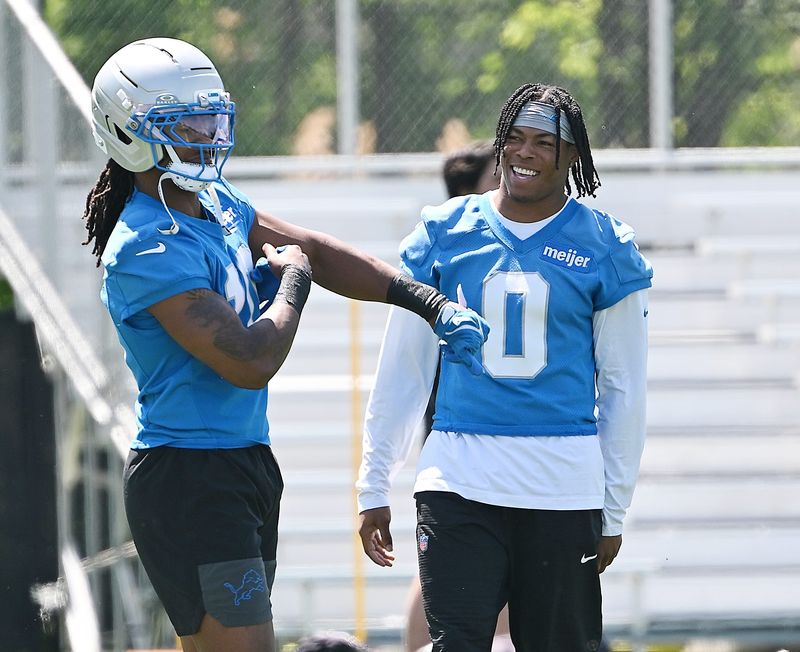 Lions running backs Isiah Pacheco (10) and Jahmyr Gibbs (0) chat before practice Friday in Allen Park.