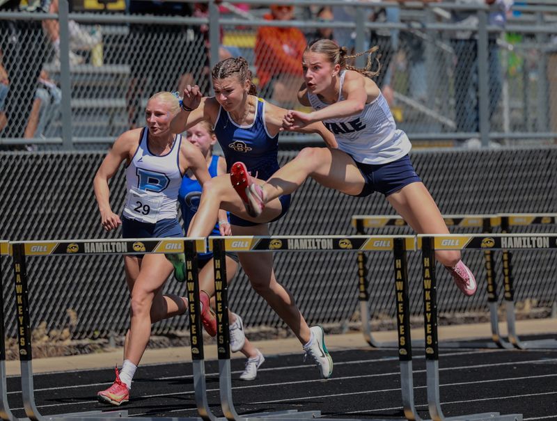 Yale's Sadie Dykstra (far right) leaps over a hurdle during the MHSAA Division 2 state finals at Hamilton Stadium on Saturday, May 30.