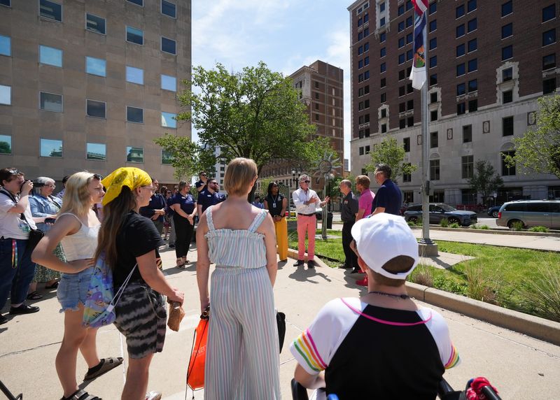 Lansing City Clerk Chris Swope, middle, speaks in front of Lansing City Hall, Monday, June 1, 2026, where people gathered for a ceremonial raising of the Pride flag marking the beginning of Pride Month.