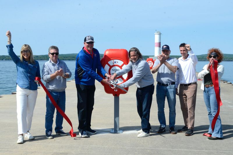 Representatives from the city and the Petoskey Yacht Club have a ribbon cutting for newly installed life rings on May 29, 2026.