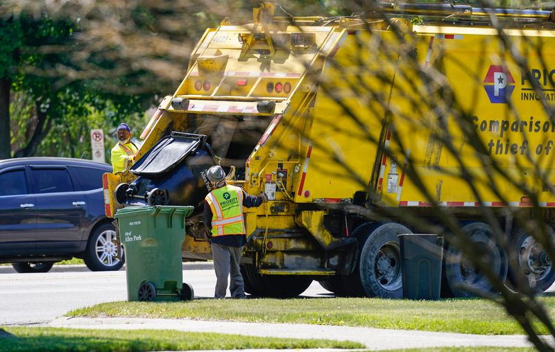 Workers on a Priority garbage truck pick up garbage along Allen Road in Allen Park on Tuesday, June 2, 2026.