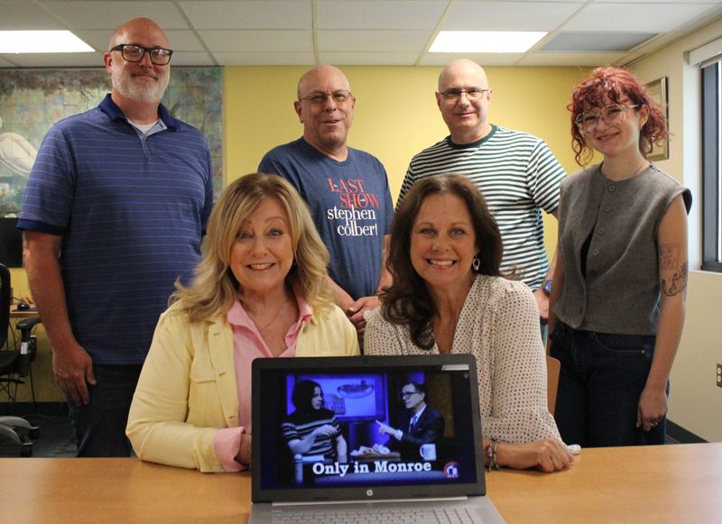 Discussing Stephen Colbert's return to "Only in Monroe," Monroe Community Media hosts Michelle Baumann (seated, left) and Kaye Lani Rae Rafko Wilson met on Tuesday, June 2, 2026, with Agora adviser Matt Bird-Meyer, Monroe County Community College journalism/humanities professor (standing, left), Brian Burchette, MCM media coordinator, Jerry Gysin, MCM radio operations manager and Maggie Robinson, former Agora editor and recent MCCC graduate.