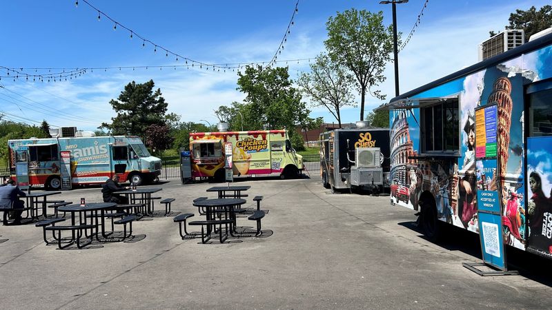 A fleet of food trucks fill a lot at The Canteen, a Dearborn food hall.