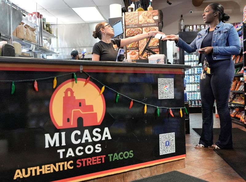Vida Chema, left, helps customer Michelle Rickman, 35, of Detroit, who had placed to-go orders for her nearby office at Mi Casa Tacos in Southfield on Wednesday, June 3, 2026. The popular Mexican restaurant inside Franklin Liquor Store has been open for three months.