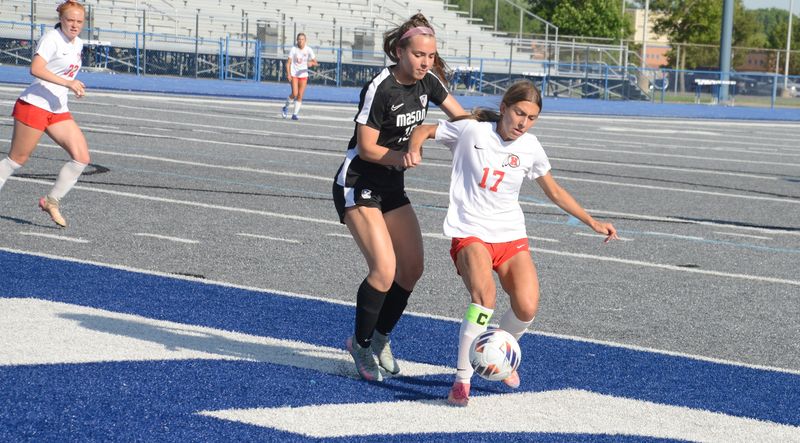 New Boston Huron's Ava Banko battles for the ball against Jocelyn Straub of Mason in the finals of the Division 2 Girls Soccer Regional at Ypsilanti Lincoln on Thursday, June 4, 2026.