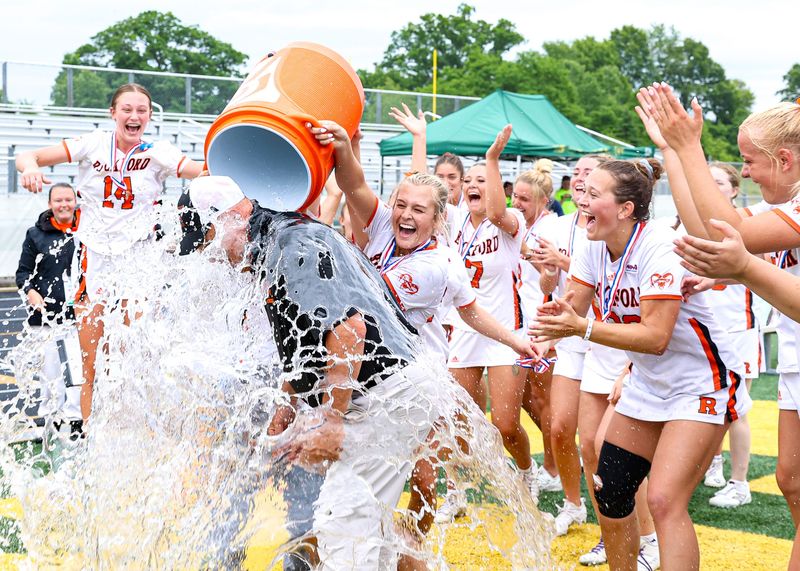 Rockford players pour water on coach Mark Neumen after the MHSAA Division 1 girls lacrosse state championship on Friday, June 5, 2026, at Parker Middle School in Howell.