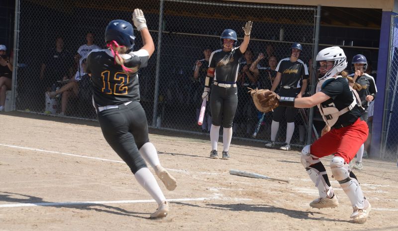 Airport's Kennady Kroll tries to avoid the tag of Milan catcher Aryana Bowden during an 11-4 Airport win in the finals of the Division 2 Regional at Fowlerville on Saturday, June 6, 2026. Kroll was called out for running out of the basepath.