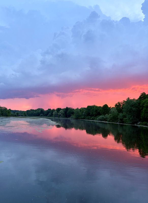 View from Maple Road bridge over the Huron River in Ann Arbor, with rain clouds in the distance, on June 10, 2026.