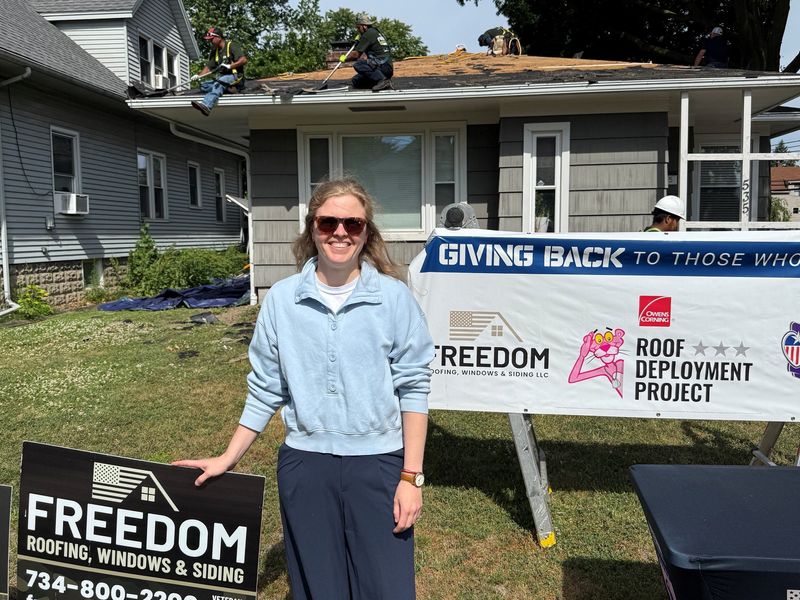 Molly Murphy of Monroe stands before her home June 17 as crews work on replacing her roof.
