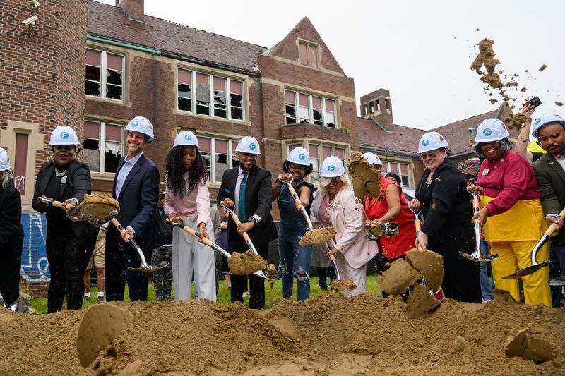Politicians, school officials, and community members throw shovelfuls of dirt during a groundbreaking ceremony for a new high school on the site of the former Flint Central high school, June 17, 2026.