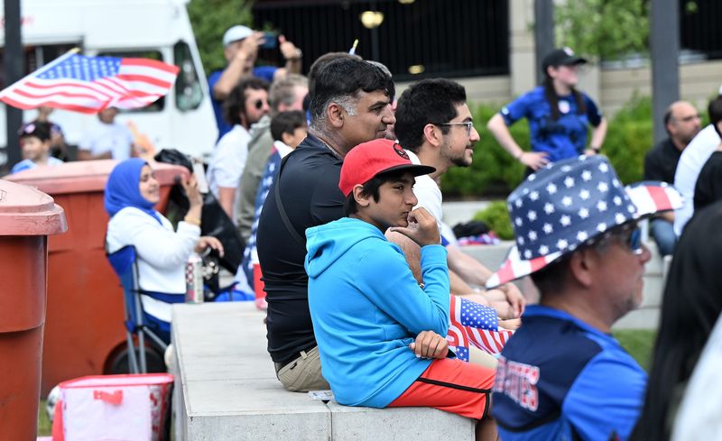Bilal Aziz, 12, of Canton, with his father, Khurram Aziz, next to him, watch during a watch party for the USA-Australia World Cup match on June 19, 2026 at PEACE Park West in Dearborn, Mich.