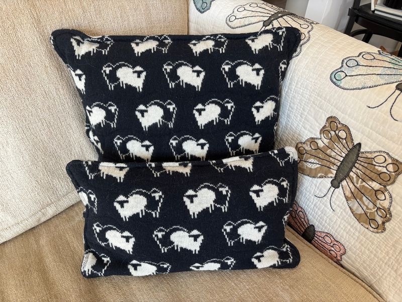 Accent pillows made from a sweater that belonged to a lost loved one feature a sheep motif.