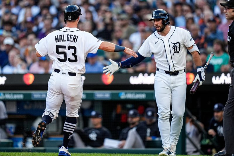 Tigers right fielder Ben Malgeri (53) celebrates scoring a run against the Yankees during the third inning with center fielder Matt Vierling (8) at Comerica Park.
