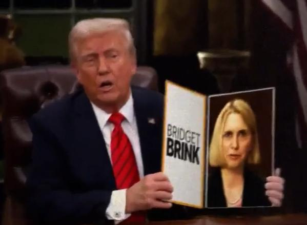 A screenshot from a Michigan Values PAC ad depicts President Donald Trump holding up a folder in which a video of former U.S. Ambassador to Ukraine Bridget Brink is featured.