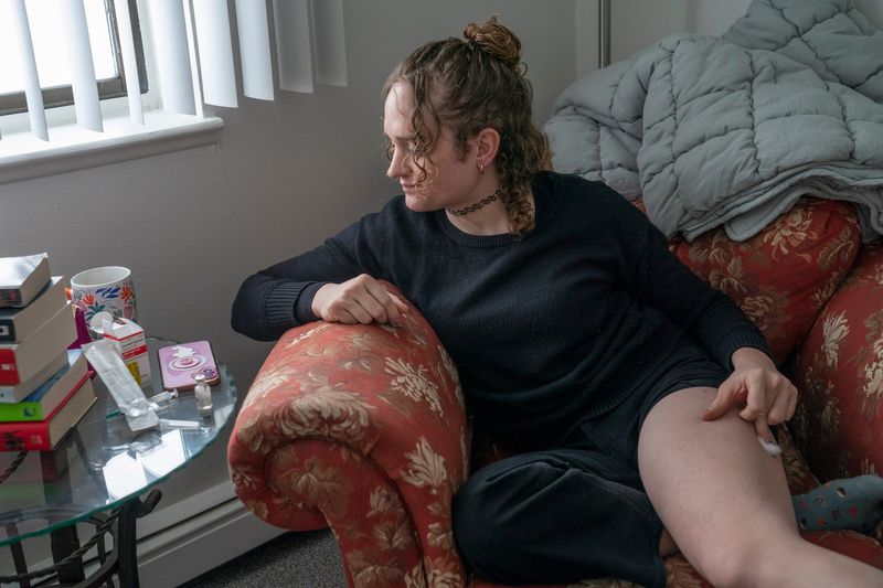 Jackie Nicholls, 29, holds a cotton swab after giving herself an Estradiol hormone shot at her west Michigan apartment on Saturday, Jan. 24, 2026.