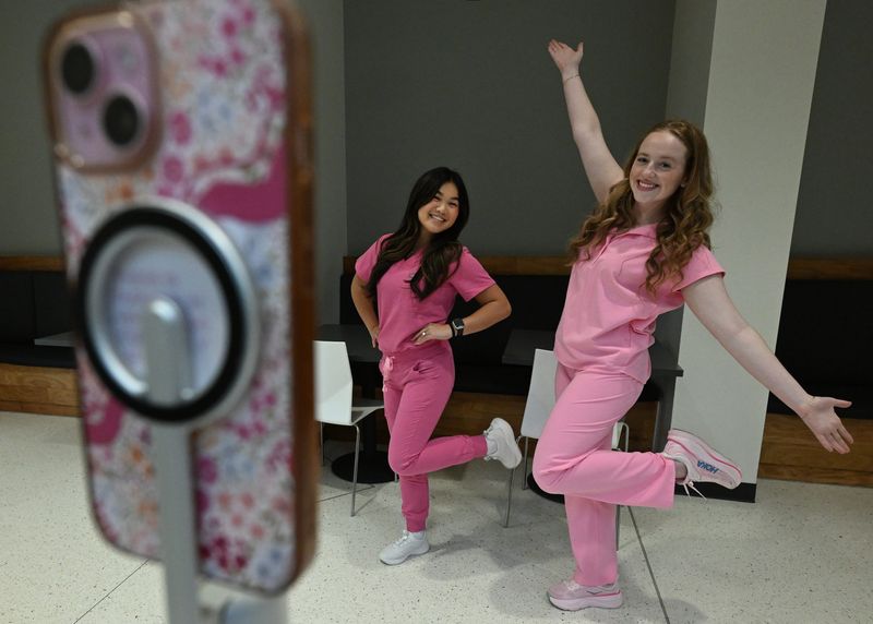 Student influencers Kendall Benson, left, and Samantha Peterson, social media influencers also known as @sam.kendall.pa, strike poses for the camera while filming content at Oakland University in Rochester Hills on June 24, 2026.