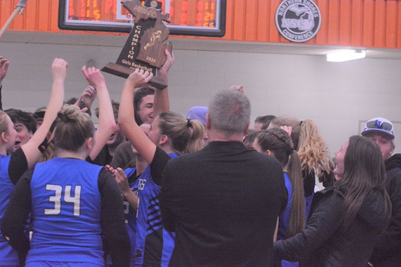 The Inland Lakes girls basketball team celebrates winning a first-ever regional championship following a victory over Newberry in March.