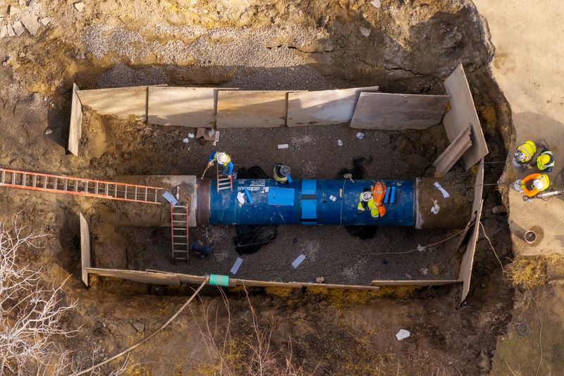 Utility crews work on repairing a water main break on 14 Mile Road east of Drake, in Farmington Hills, March 9, 2026.  (David Guralnick / The Detroit News)