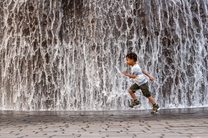 Eazy Colding, 4, of Redford, races in the mist from the Horace Dodge Fountain in Hart Plaza in downtown Detroit on Saturday, June 27. Eazy was with his father Shawn Colding and mother Krystal. Temperatures are expected to soar up to 100 degrees this week in metro Detroit.