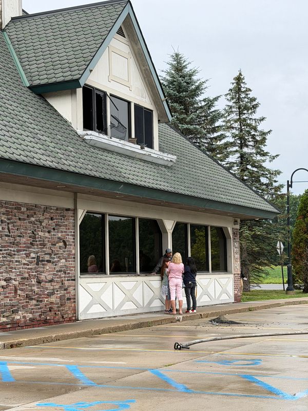 Dorsey House owner Ryan Clift, center, speaks with family members outside the front of the Dorsey House in Clyde Township on Sunday, July 5, 2026, after a fire damaged the historic restaurant.