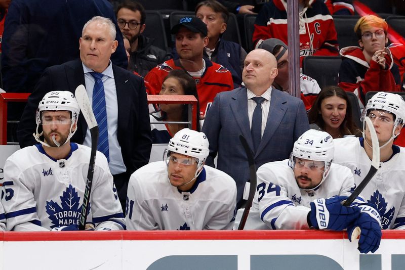 Maple Leafs head coach Craig Berube (L) and assistant coach Derek Lalonde (R) look on from behind the bench against the Capitals during the second period at Capital One Arena.