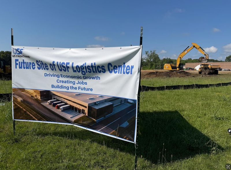A sign marks the future site of the US Farathane logistics center as construction equipment works nearby on Dove Street in Port Huron’s industrial park on July 7, 2026.
