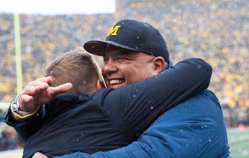 Michigan Athletic Director Warde Manuel smiles broadly while getting a congratulatory hug in the final moments of Michigan’s 42-27 victory over their arch rivals, Ohio State at Michigan Stadium in Ann Arbor on Saturday, Nov. 27, 2021.