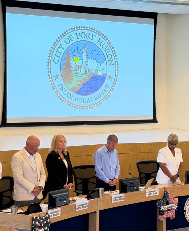 From left, Port Huron City Council members Conrad Haremza and Barbara Payton, City Manager James Freed and Mayor Anita Ashford stand during the opening of the Port Huron City Council meeting on July 13, 2026.
