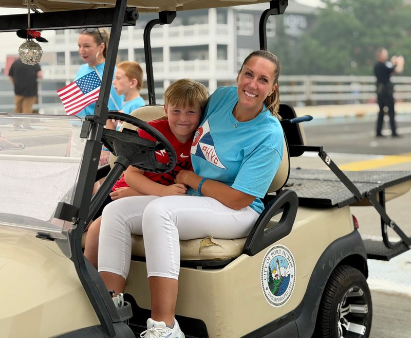 Downtown Development Authority Director Lisa DeLong, right, smiles with her son, Gavin, 8, while riding in the 106th Rotary International Day Parade in Port Huron on Wednesday, July 15, 2026.