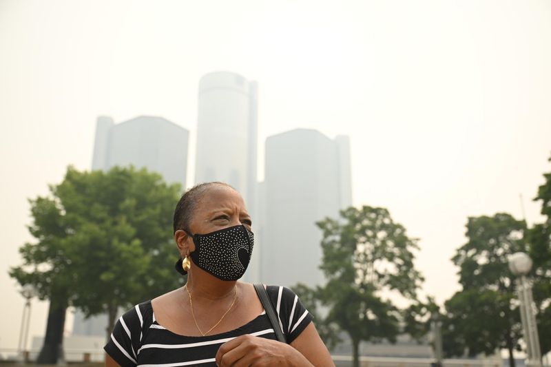 Classie Parker, of Detroit, walks through Hart Plaza wearing a mask, July 16, 2026. Smoke from Canadian wildfires has given Detroit the most polluted air in the world among major cities on Thursday, according to a Swiss air quality technology company.