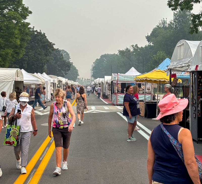 People mill about at the Ann Arbor Street Art Fair as smoke from wildfires in Canada and Minnesota hang in the air, Thursday, July 16, 2026, in Ann Arbor.